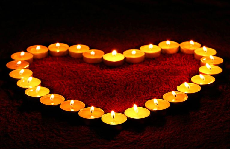 Candles set in the shape of a heart giving of a delicate orange glow for love and remembrance
