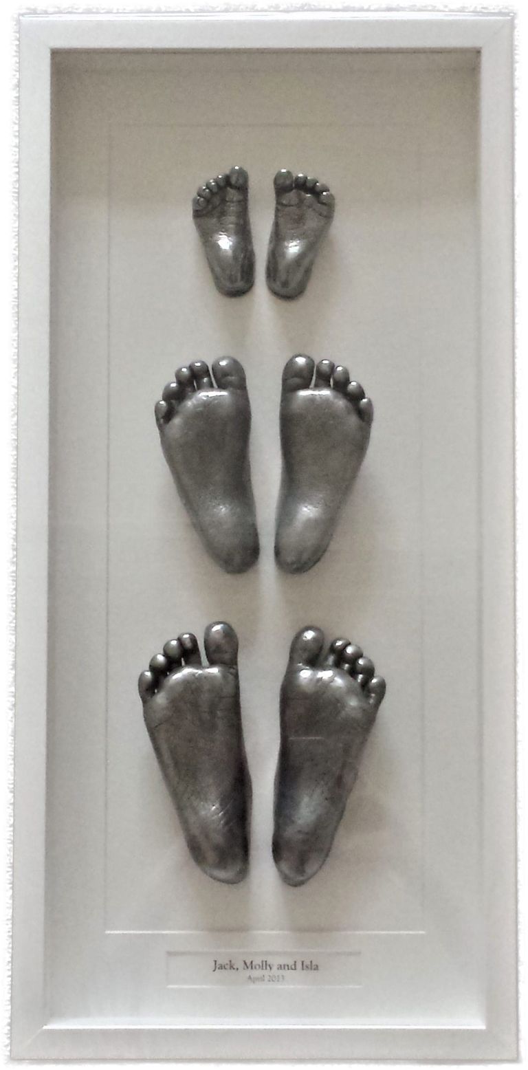 Three pairs of different aged siblings feet showing a point in time. Aluminium cold cast in a bespoke white box frame.